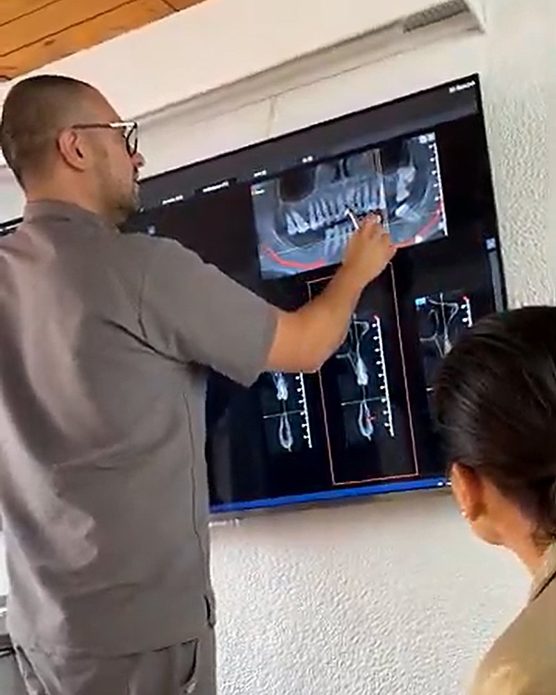 Dr. Juan Pablo Vela explica un caso a su paciente en Vela Odontología, Quito