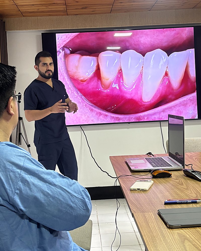 Dr. Diego Espinosa explica un caso a su paciente en Vela Odontología, Quito